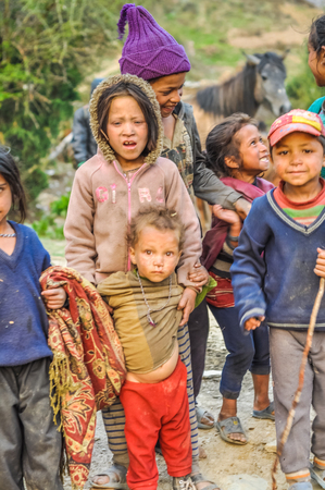 Dolpo, Nepal - circa May 2012: Group of native children look curiously to photocamera and pose in Dolpo, Nepal. Documentary editorial.のeditorial素材