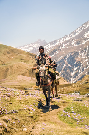 Dolpo, Nepal - circa May 2012: Native man sits on horse in beautiful mountainous countryside of Dolpo, Nepal. Documentary editorial.のeditorial素材