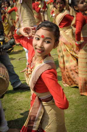 Guwahati, Assam - circa April 2012: Young native girl in red and yellow sari dances during performance at Bihu festival in Guwahati, Assam. Documentary editorial.のeditorial素材