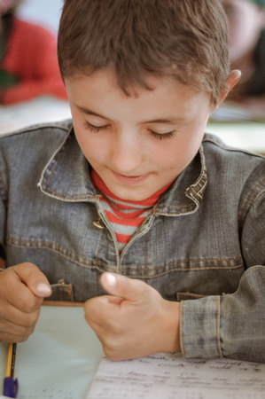 Khorog, Tajikistan - circa September 2011: Small boy has closed eyes and learns to count using his fingers during lesson of mathematics at school in Khorog, Tajikistan. Documentary editorial.のeditorial素材