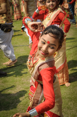 Guwahati, Assam - circa April 2012: Photo of smiling young girl in beautiful sari with red dot on her forehead dancing during performance at Bihu festival in Guwahati, Assam. Documentary editorial.のeditorial素材