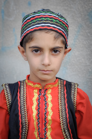 Bajgiran, Iran - circa June 2011: Small boy poses in traditional folk costume at wedding in Bajgiran, Iran. Documentary editorial.のeditorial素材