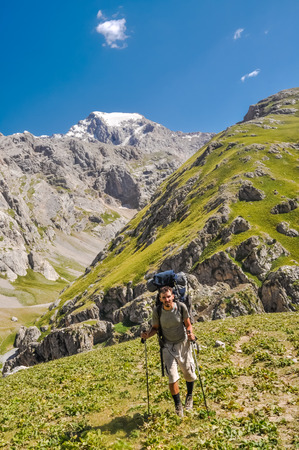Arslanbob, Kyrgyzstan - circa July 2011: Young man hikes in beautiful mountainous countryside of Arslanbob, Kyrgyzstan. Documentary editorial.のeditorial素材