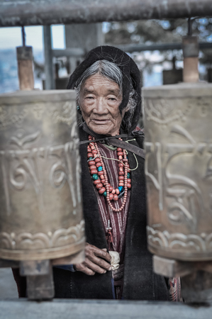 Tawang, Arunachal Pradesh - circa February 2012: Old woman in black clothes and with red necklace from beads in Tawang, Arunachal Pradesh. Documentary editorial.のeditorial素材