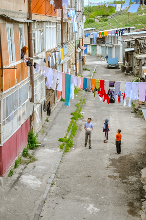 Abovian, Armenia - circa May 2011: Children play in front of their house in Abovian, Armenia. People dry their clothes on clothes lines. Documentary editorial.のeditorial素材