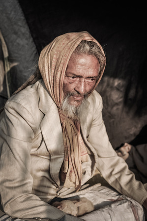 Shantiniketan, West Bengal - circa January 2012: Older man with grey beard and yellow headcloth on his head wears suit at Baul music festival near Shantiniketan, West Bengal. Documentary editorial.のeditorial素材
