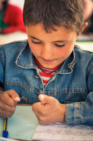 Khorog, Tajikistan - circa September 2011: Small boy learns to count using his fingers during lesson of mathematics at school in Khorog, Tajikistan. Documentary editorial.のeditorial素材