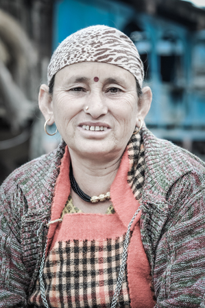 Manali, Himachal Pradesh - circa November 2011: Woman with headcloth, earrings and red bindi on her forehead look to photocamera in Manali. Documentary editorial.のeditorial素材