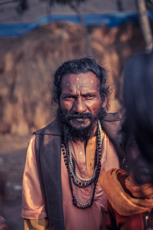 Shantiniketan, West Bengal - circa January 2012: Man with black hair and beard has symbol on his forehead and wears string of beads at Baul music festival, West Bengal. Documentary editorial.のeditorial素材