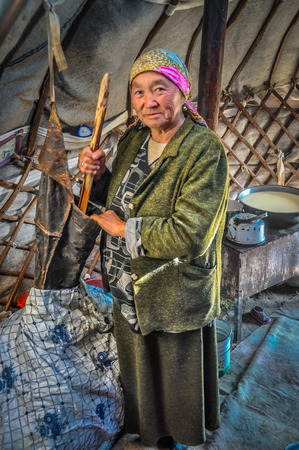 Son Kol, Kyrgyzstan - circa September 2011: Older native woman with headcloth poses in her nomad tent in Son Kol, Kyrgyzstan. Documentary editorial.のeditorial素材