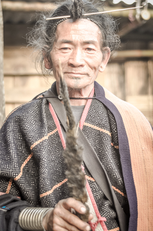 Ziro, Arunachal Pradesh - circa March 2012: Smiling native man in traditional clothes and with typical hairstyle poses in Ziro, Arunachal Pradesh. Documentary editorial.のeditorial素材