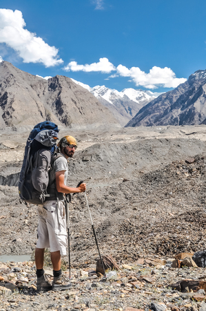 South Inylchek Glacier, Kyrgyzstan - circa August 2011: Man with large rucksack and trekking poles poses near South Inylchek Glacier, Kyrgyzstan. Documentary editorial.のeditorial素材