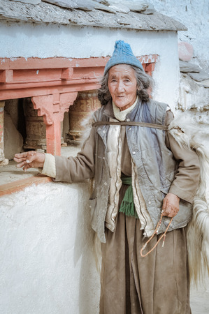 Lamayuru, Ladakh - circa November 2011: Old native woman with tanned face wears typical clothes and blue cap on her head in Lamayuru, Ladakh. Documentary editorial.のeditorial素材