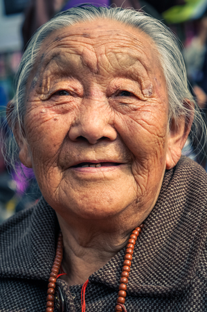 Bohdgaya, Bihar - circa January 2012: Older woman with grey hair and wrinkled face during teachings in Bohdgaya, Bihar. Documentary editorial.のeditorial素材