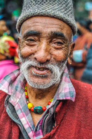 Bohdgaya, Bihar - circa January 2012: Smiling man with grey beard on tanned face and cap on his head at school in Bohdgaya, Bihar. Documentary editorial.のeditorial素材