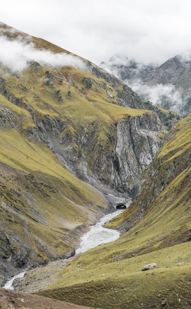 Deep valley with stream in Kashmir mountains in India on cloudy day.の写真素材