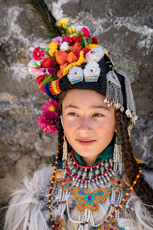 Ladakh, India - August 29, 2018: Portrait of an indigenous girl in traditional costume in Ladakh, India. Illustrative editorial.のeditorial素材