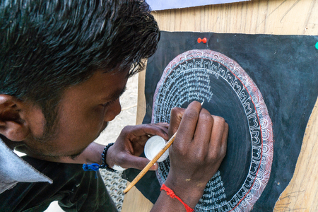 Leh, India - August 24, 2018: Man drawing a buddhist symbol in the streets of Leh. Illustrative editorial.のeditorial素材