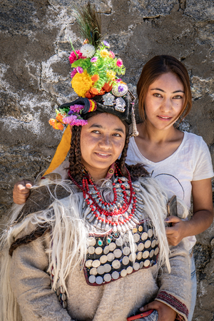 Ladakh, India - August 29, 2018: Portrait of two indigenous sisters in Ladakh, India. One in traditional festive dress, the other one in modern clothes. Illustrative editorial.のeditorial素材