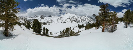 Pacific Crest Trail. A snow covered mountain range with a lake in the foreground. The sky is clear...