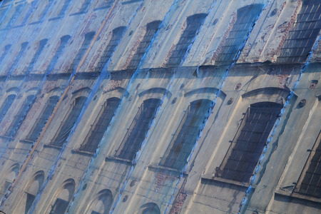 Facade of an old factory covered with protective blue meshの写真素材