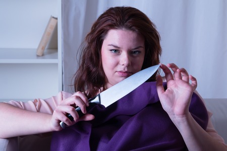 Dangerous woman with a knife in his hand - studio shootの写真素材