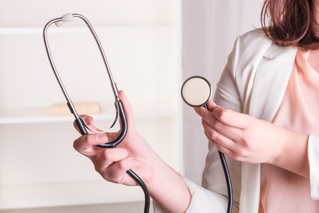 Doctor's hand holding a stethoscope in officeの写真素材