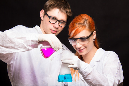 Two chemists holding a test tube in a lab - studio shootの写真素材