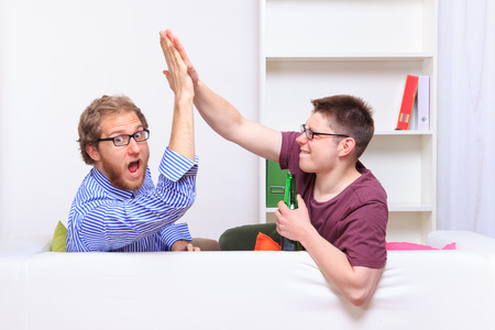 Giving friend a high five at homeの写真素材