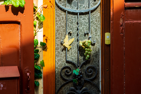 Ornamental old house door with grape decorationの写真素材