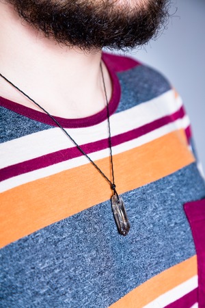 Man with a pendant made of a rhinestone mountain crystal around his neckの写真素材