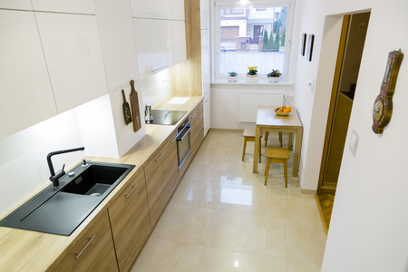 Aesthetic modern narrow kitchen with wooden furnituresの写真素材