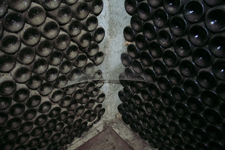 Old wine bottles laying in wine cellarの写真素材