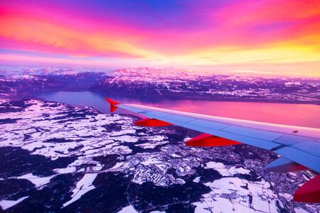Amazing view from the airplane window during the sunset over Alps in Switzerlandの写真素材