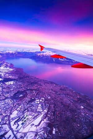 Amazing view from the airplane window during the sunset over Alps in Switzerlandの写真素材