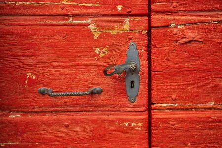 Vintage red wooden door with old iron handleの写真素材