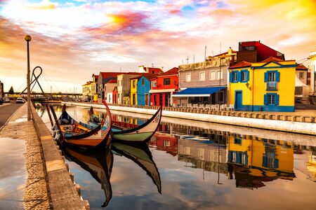 Aveiro, Portugal, Traditional colorful Moliceiro boats docked in the water canal among historical buildings.の写真素材