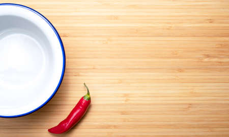 hot pepper and white plate on a wooden table