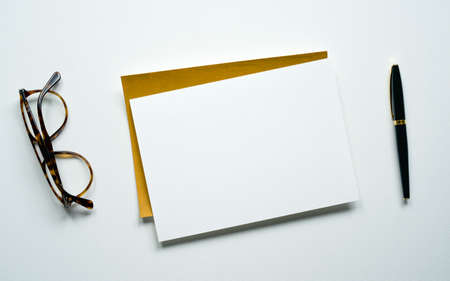 blank white invitation template, rectangle, art canvas texture, brown glasses and elegant pen, white background, photo taken from aboveの写真素材