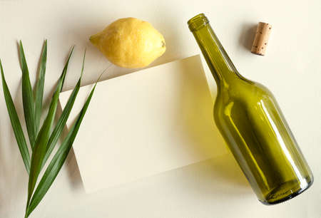 blank white invitation template, rectangle, art canvas texture, soft shadows, leaves and lemon decoration, wine bottle, white background, canvas texture, photo taken from aboveの写真素材