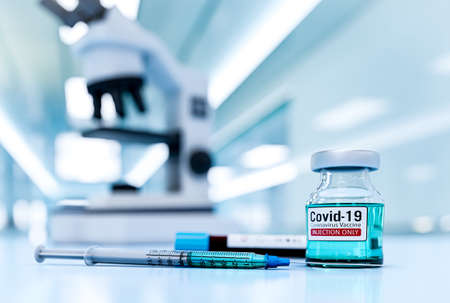 Coronavirus vaccine was invented - a vial with a liquid and a syringe on the background of a...