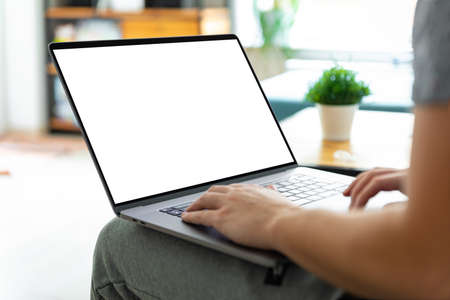 Man using laptop blank screen while sitting on sofaの写真素材