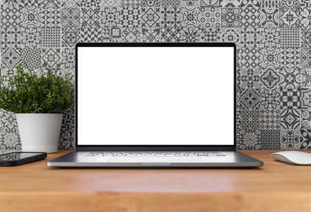 Laptop with blank screen on table in home interior with pattern tiles in the backgroundの写真素材