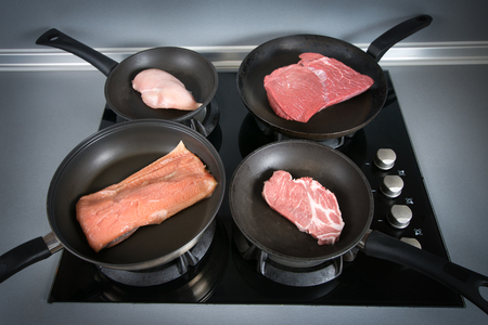 Diffrent types of raw meats on a pans. There is chicken, beef, pork and fish. Photo is horizontal and shoot in a kitchen.の写真素材