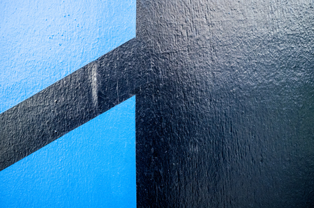 Texture of a great looking outdoor wall in the city.  It is black with blue lines on the left side.の写真素材