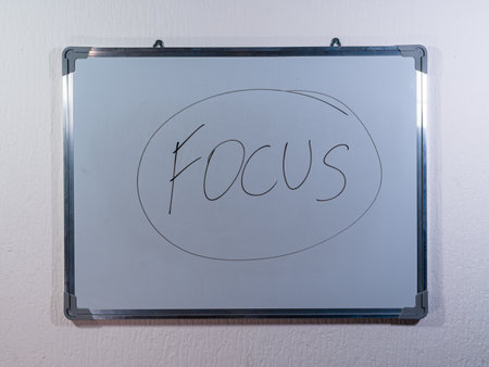 Whiteboard showing FOCUS concept in circle shape representing concentration, attention and mental clarityの写真素材