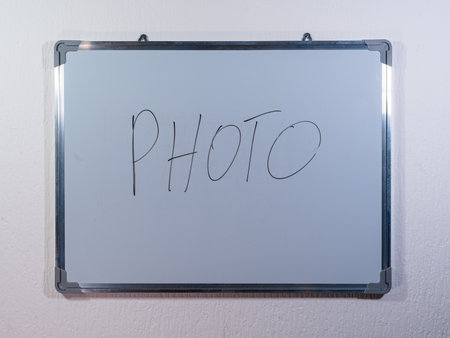 Whiteboard showing PHOTO concept on clean white wall background representing photography, image creation and visual storytellingの写真素材