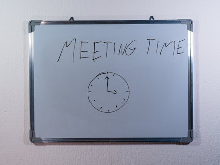 Whiteboard with handwritten text on clean white wall background representing time management and productivity conceptの写真素材