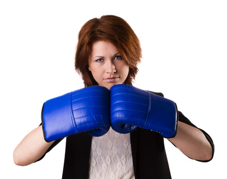 Businesswoman in suit punching with red boxing gloves isolated on white backgroundの写真素材