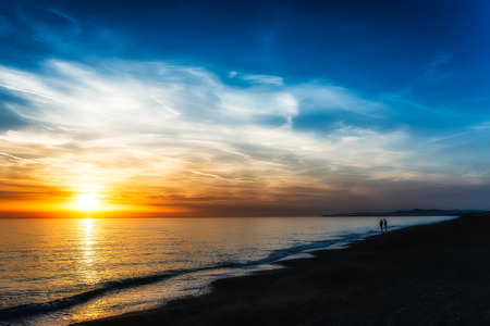 sunset over the sea with a coupleの写真素材